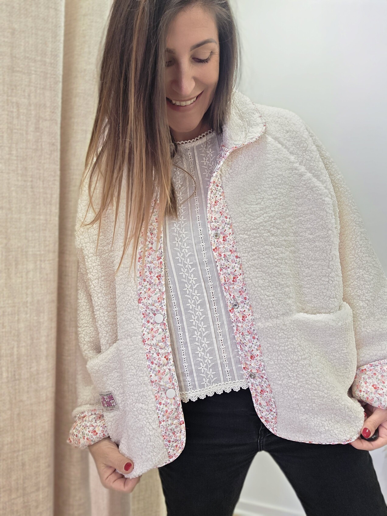 Veste Bear réversible ouverte montrant côté sherpa écru et côté fleuri